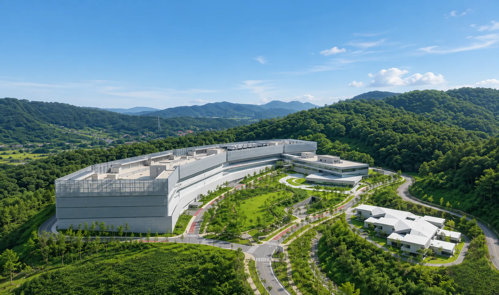 A vast data-center campus set among green hills under a blue sky